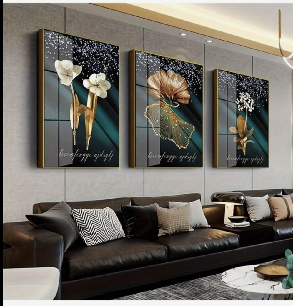 Three artistic wall hangings above a sofa in a living room.